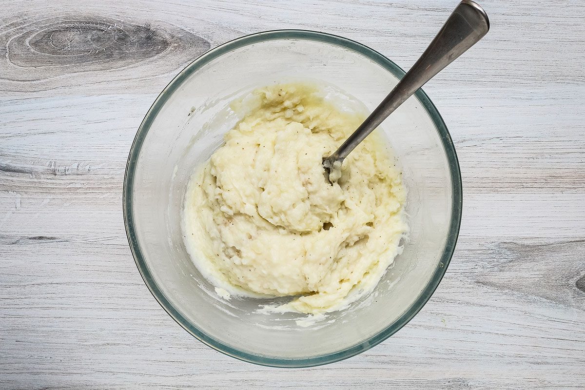 Stirring salt and pepper into the microwave mashed potatoes.