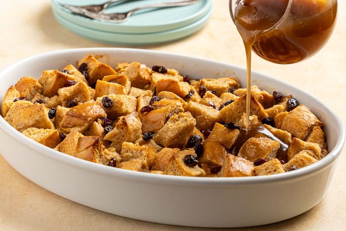 adding sauce onto New Orleans Bread Pudding