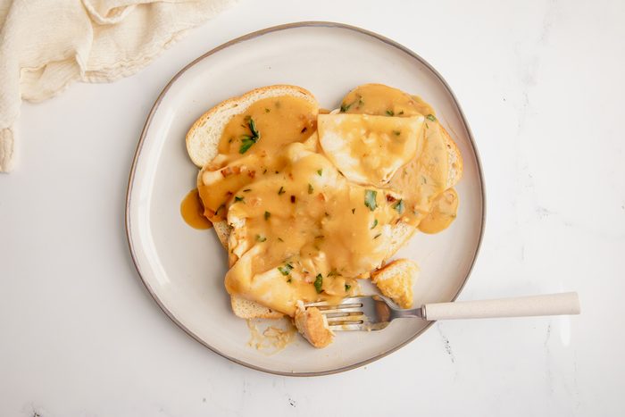 Overhead shot for Taste of Home Open Faced Turkey Sandwich, cooked and being served with gravy on a plate.
