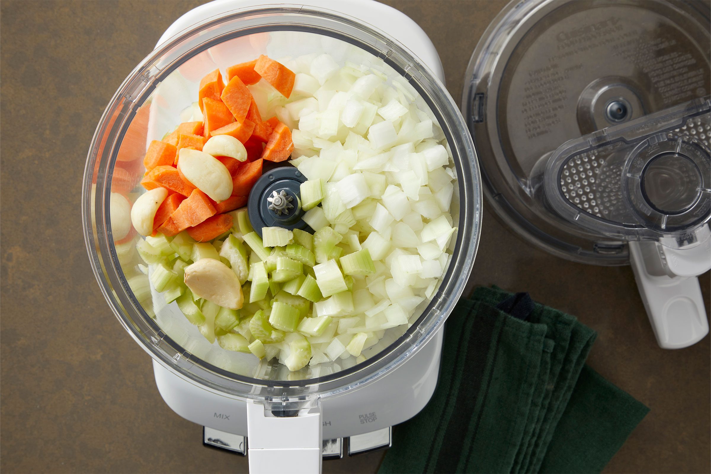 Onions, celery, carrot and garlic in a food processor to prepare Pappardelle Bolognese