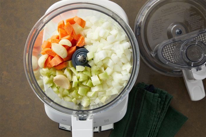 Onions, celery, carrot and garlic in a food processor to prepare Pappardelle Bolognese