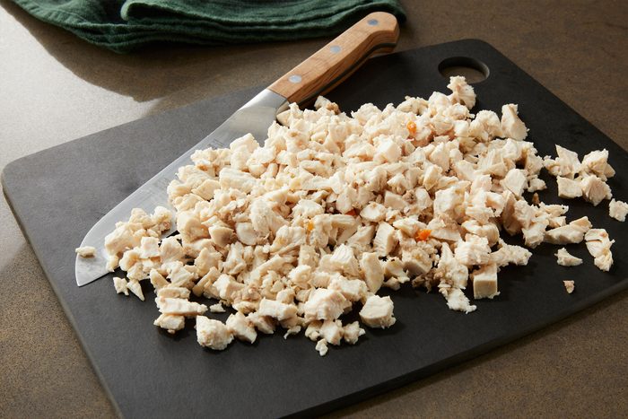Finely chopped chicken on a back cutting board