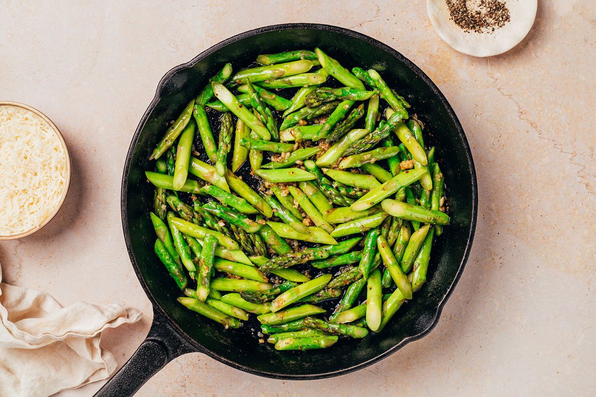 Asparagus being cooked in a cast iron pan for the Pasta with Asparagus recipe by Taste of Home