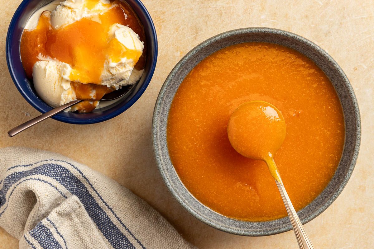 Taste of Home Peach Syrup photo of the finished recipe poured over ice cream.