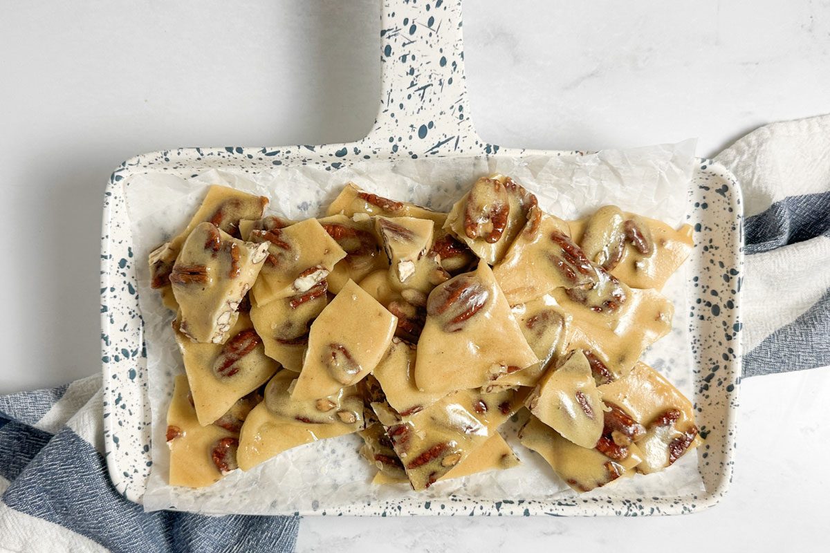Taste of Home Pecan Brittle on a speckled ceramic tray