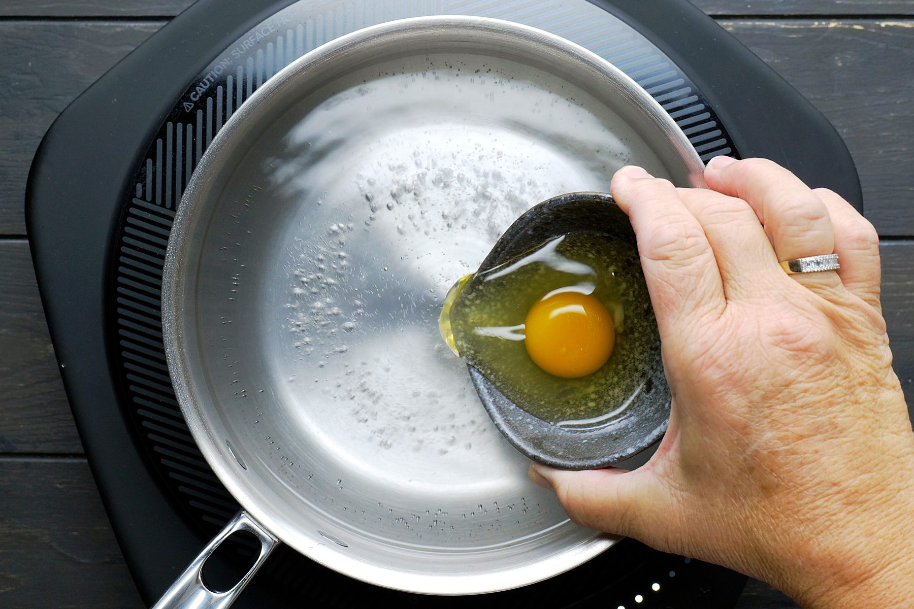 Gently stir the eggs in the simmering water in a clockwise motion.