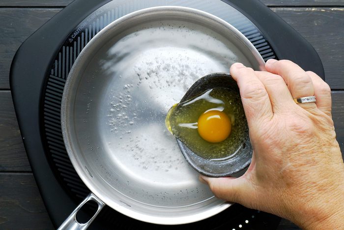 Gently stir the eggs in the simmering water in a clockwise motion.