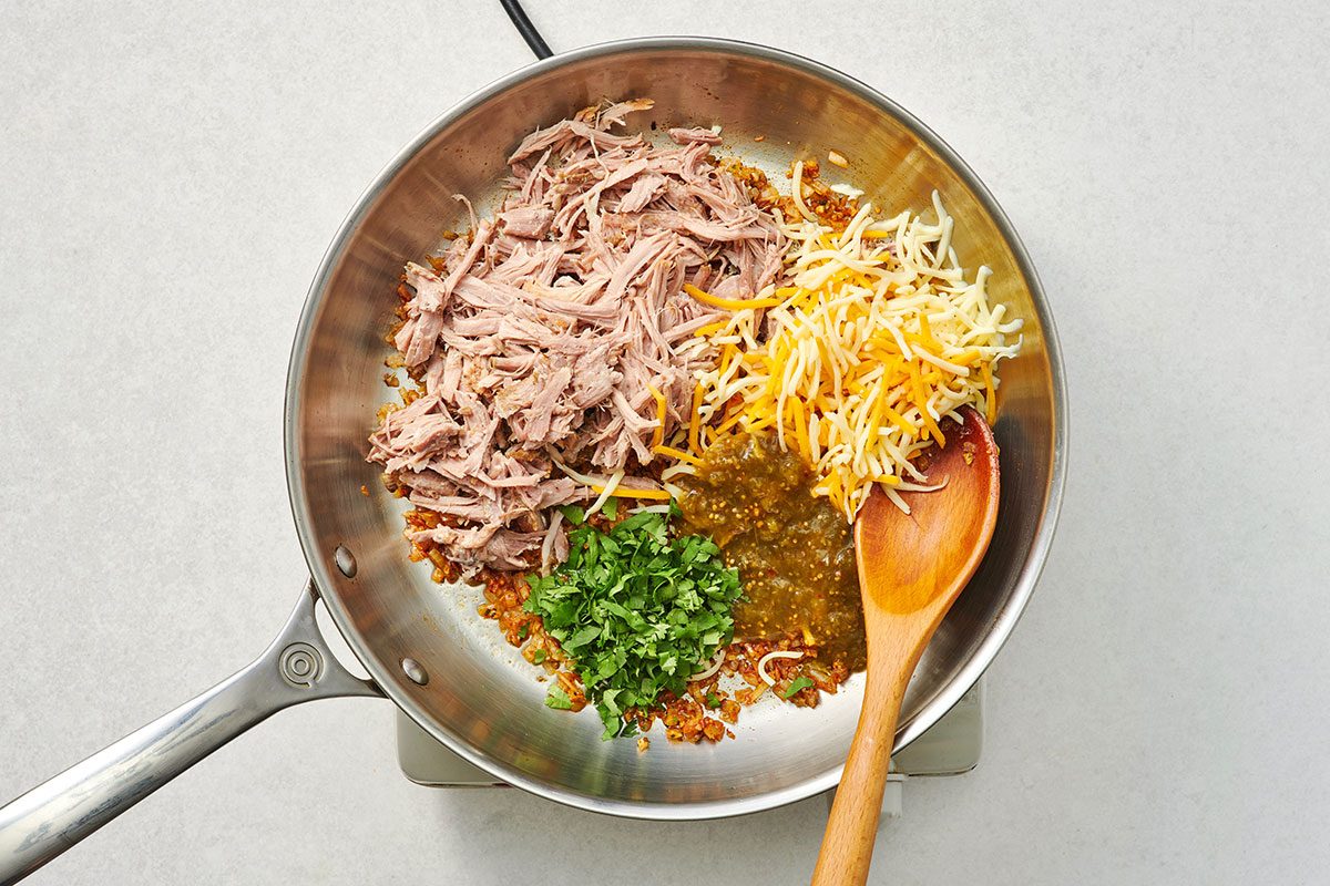 Stirring in the pork cheese cilantro salsa and lime juice