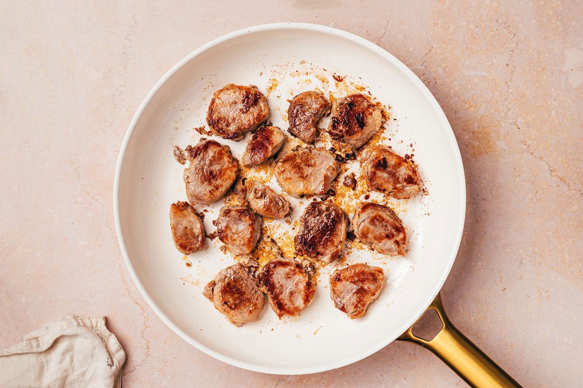 Browned pork tenderloin in a large skillet, a step of the Pork Tenderloin with Gravy recipe by Taste of Home