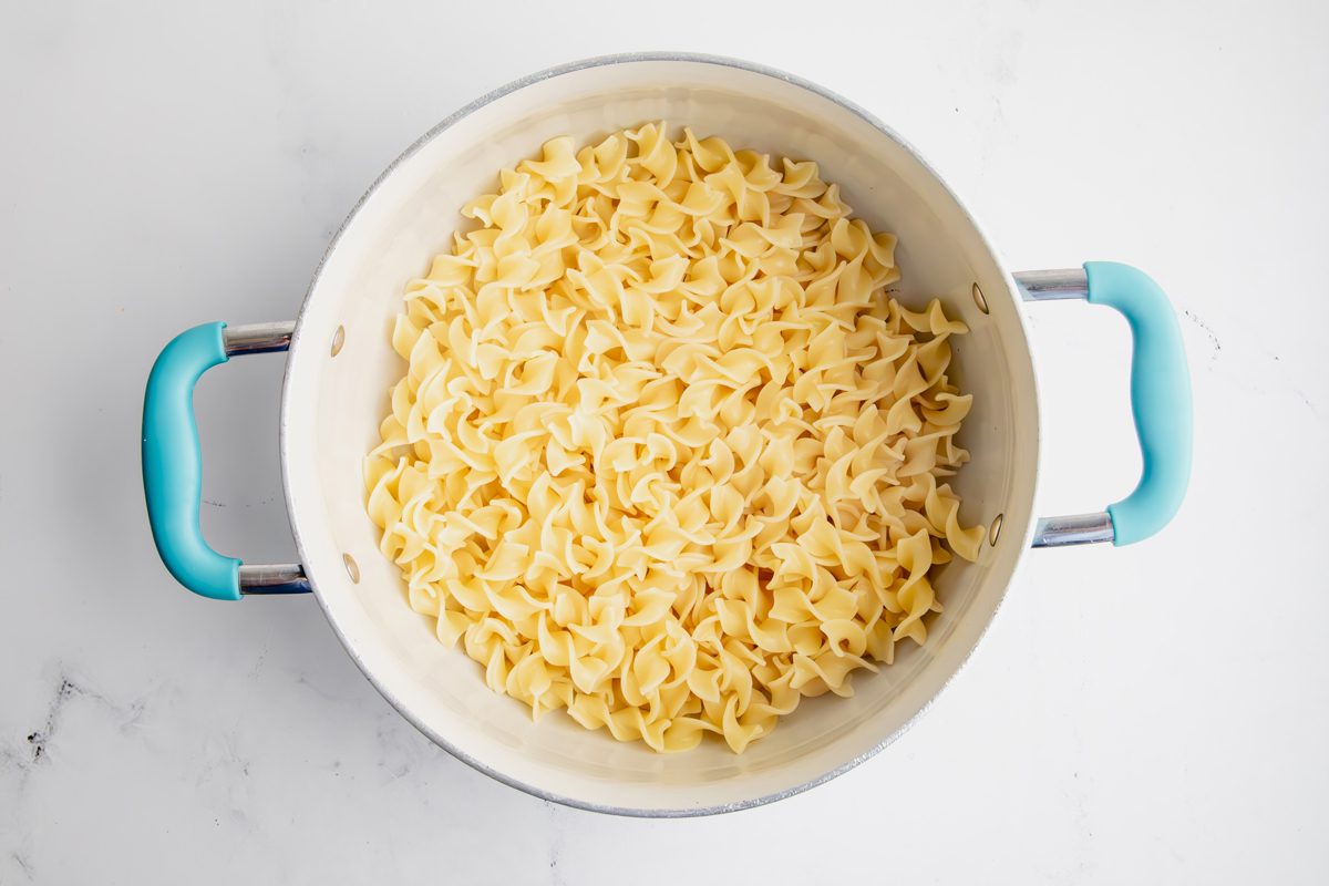 Overhead shot for Taste of Home Pork Chops and Noodles, noodles cooked in a large saucepan.