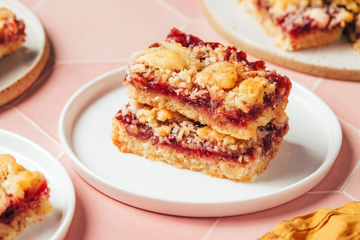 Two stacked raspberry bars with coconut on a small white plate, recipe by Taste of Home