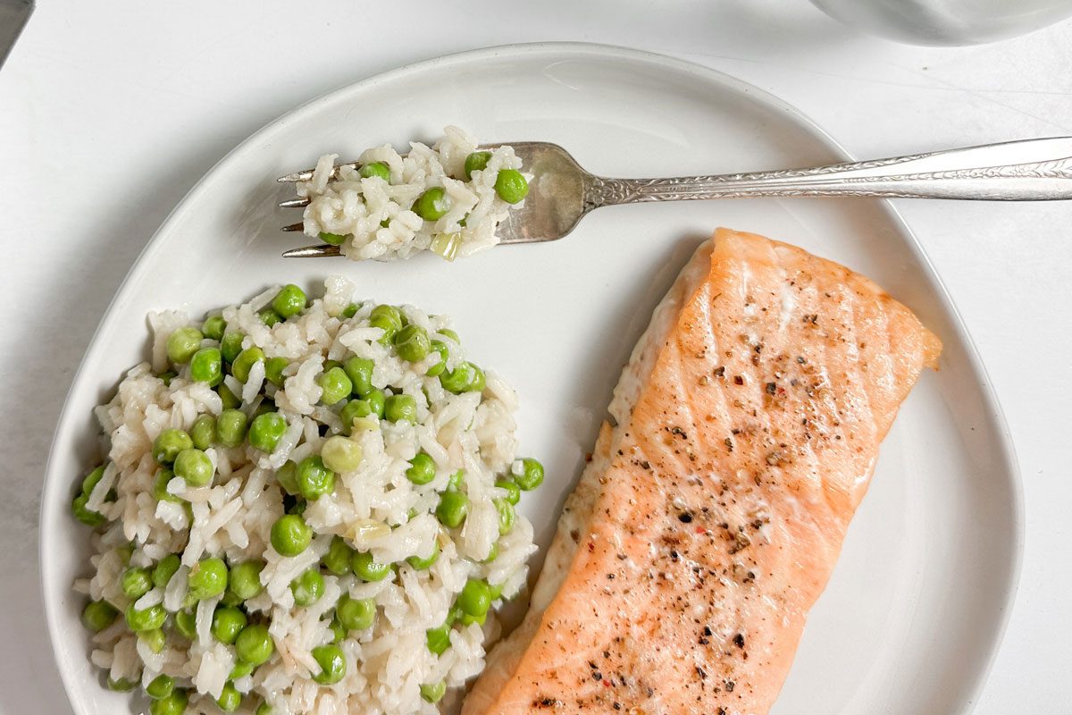 Taste of Home Rice and Green Peas on a white plate with salmon