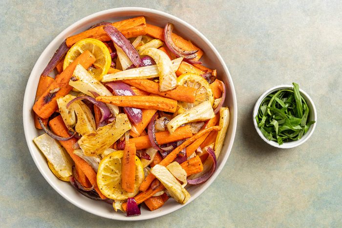 Taste of Home Roasted Fennel and Carrots photo of the roasted veggies on a serving platter with basil to garnish.