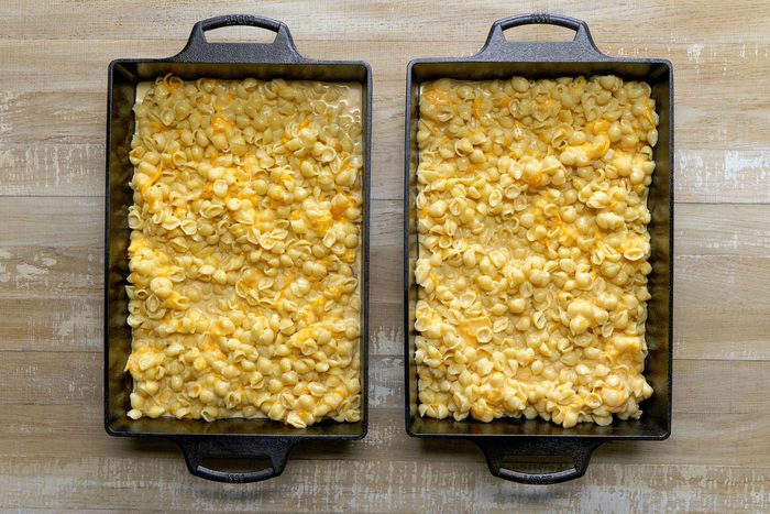Pasta mixture spooned evenly into two greased baking pans.