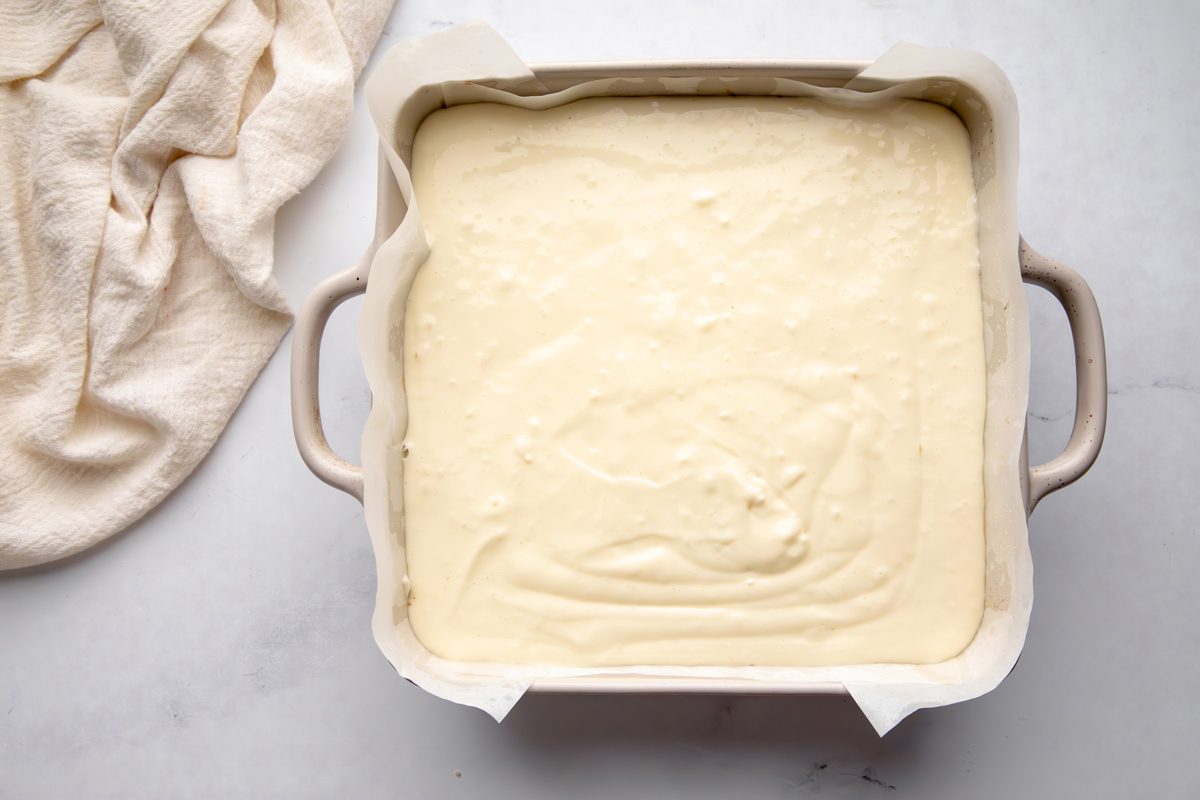 Overhead shot for Taste of Home Snickerdoodle Cheesecake Bars, cheesecake filling on top of cookie crust before being baked.