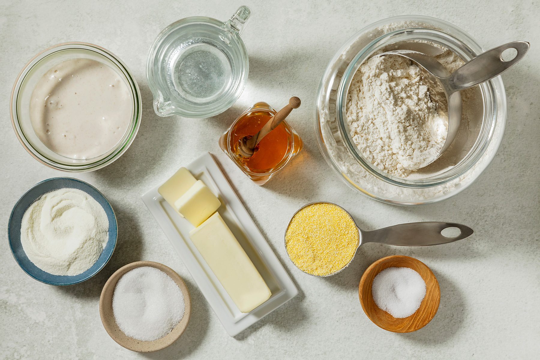 overhead shot of Sourdough English Muffins ingredients placed over white background