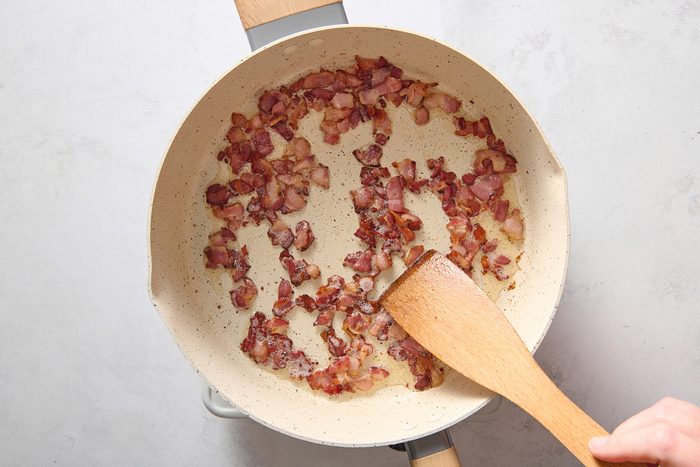 Frying the bacon in a large skillet
