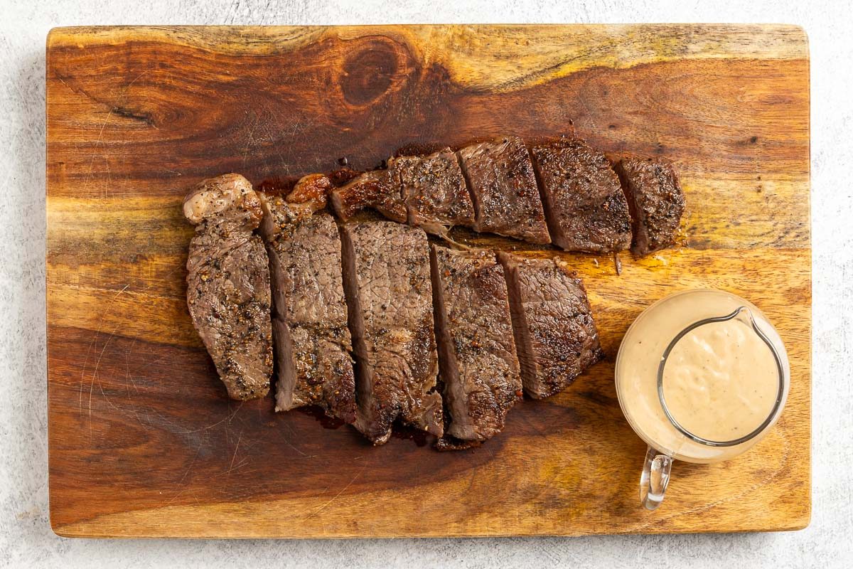 steak sliced with the sauce on the side