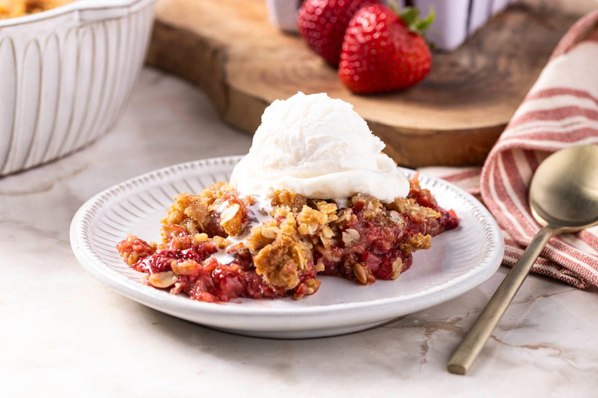 Strawberry Crisp served with ice cream 3/4 view on marble table
