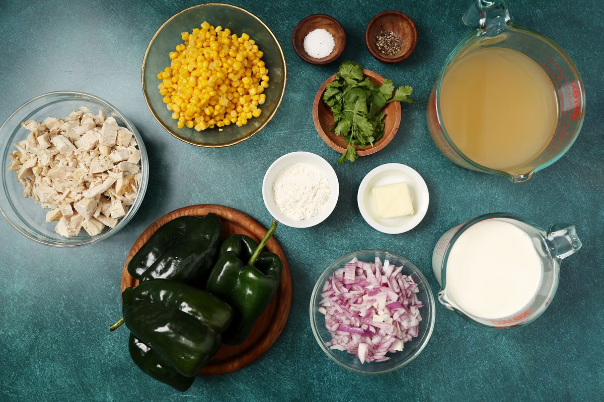 Ingredients for Taste of Home's Poblano Soup laid out in small bowls on a teal surface.