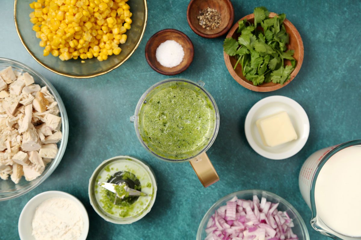 Process of making Taste of Home's Poblano Soup poblano sauce in a blender on a teal surface.