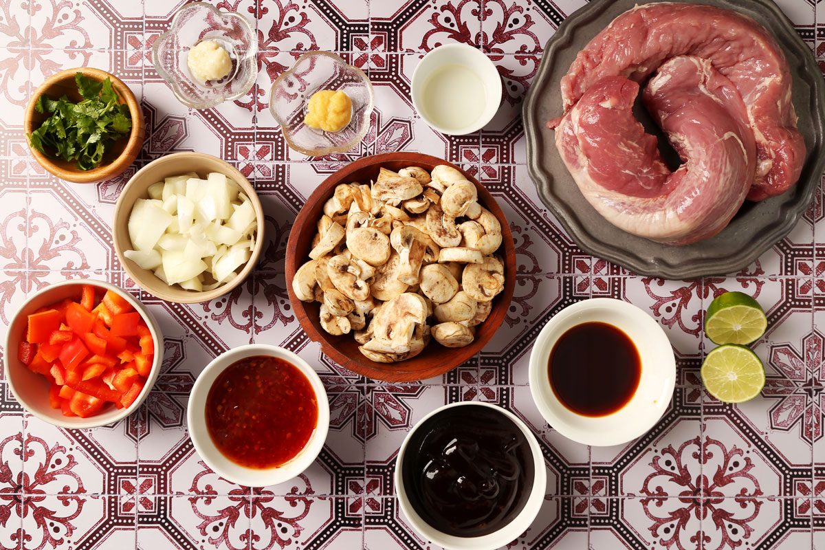 Ingredients for Taste of Home's Pork Bowl laid out in small bowls on a red and white tiled surface.