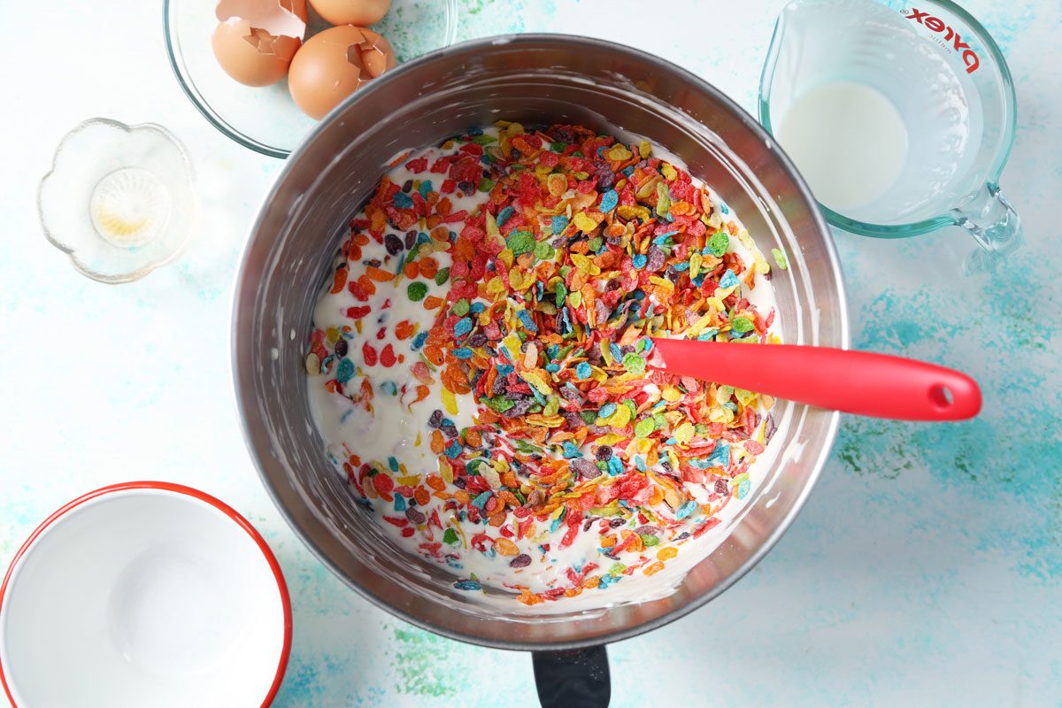 Process of making Taste of Home's Fruity Pebbles Cheesecake mixed in a large bowl.
