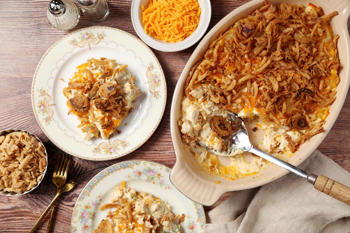 Close up of Taste of Home's French Onion Chicken Casserole served on a plates on a brown wooden surface.