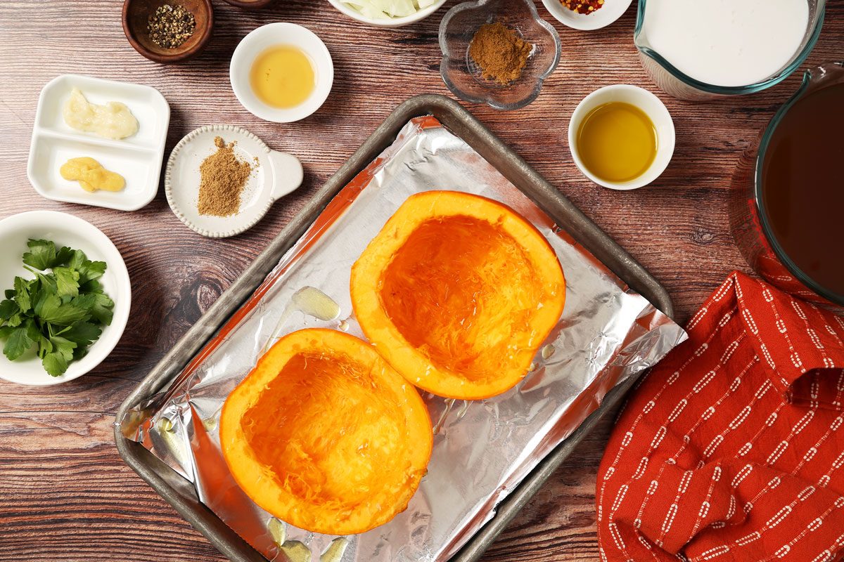 Process of making Taste of Home's Chicken Pumpkin Soup in a dutch oven on a brown wooden surface.