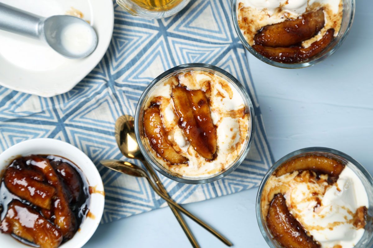 Close up of Taste of Home's bananas foster laid out on a light blue surface with a blue linen.