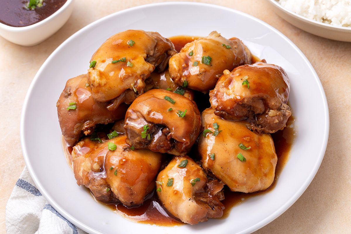 Teriyaki Chicken Thighs on a serving platter garnished with green onion for Taste of Home
