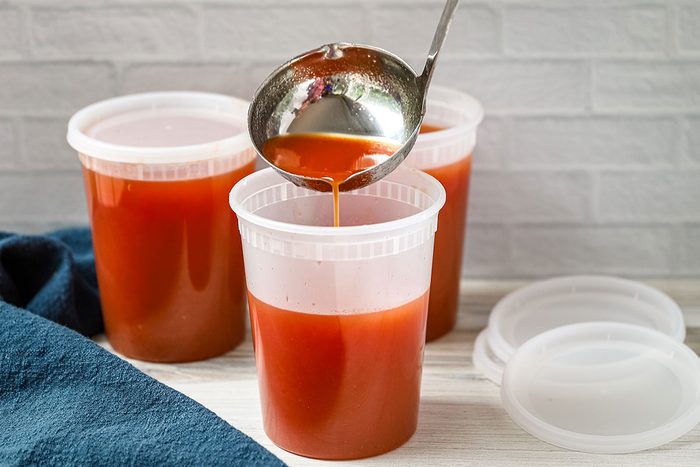 Pouring homemade spicy tomato juice into 1-quart containers, a recipe from Taste of Home.