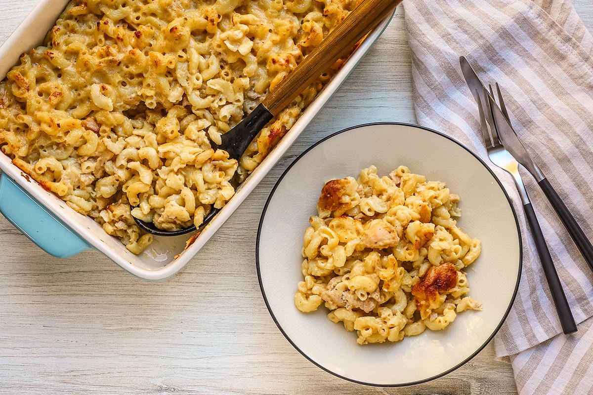 Serving tuna mac and cheese with the baking dish nearby.