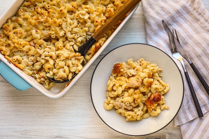 Serving tuna mac and cheese with the baking dish nearby.