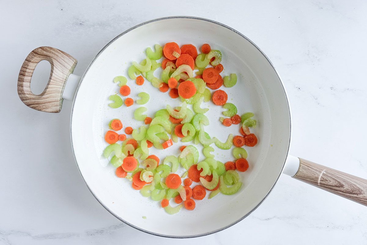 Carrots and celery for Taste of Home Turkey Curry in a white skillet