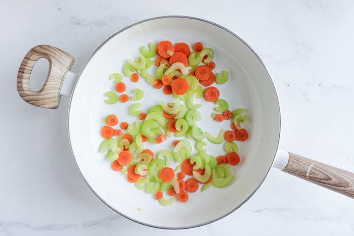 Carrots and celery for Taste of Home Turkey Curry in a white skillet