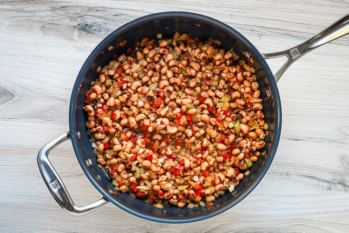 The black-eyed peas, soy sauce, liquid smoke, and vegetable broth are added to the sautéed aromatics and spices.