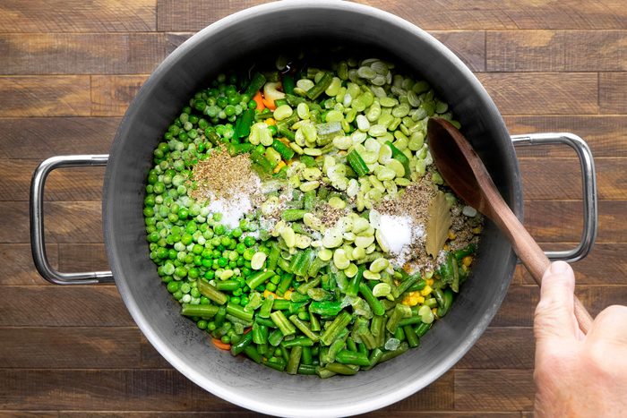 Fill the pot with a variety of vegetables, including green beans, peas, corn, carrots, and lima beans