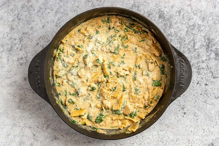 Taste of Home White Lasagna Soup photo of finishing the dish with spinach and cheese.