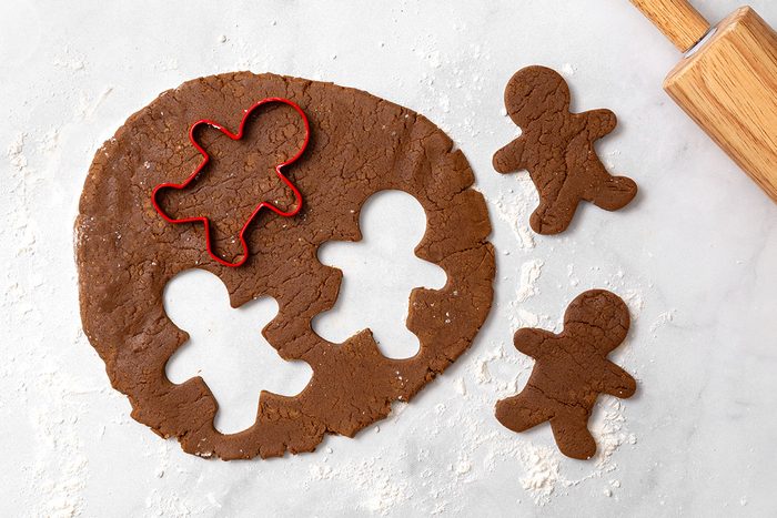 Gingerbread cookie dough rolled out on a floured surface with gingerbread cut outs for step four of Wookie Cookie recipe for Taste of Home