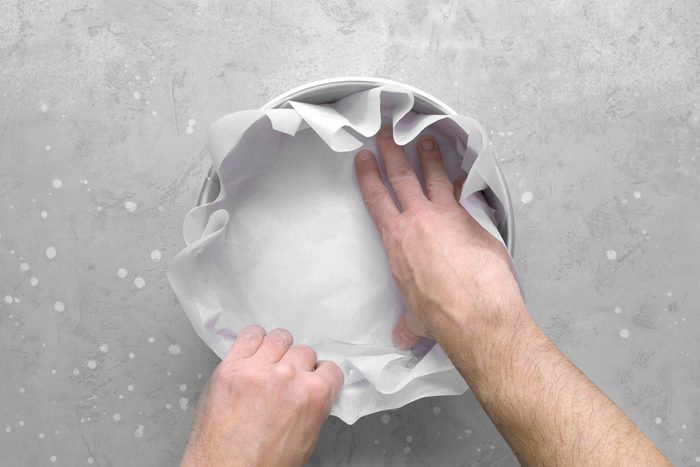 Line a 9-inch springform pan with two overlapping pieces of parchment paper, ensuring the sides are covered.