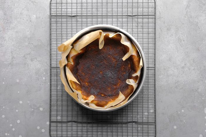 Overhead shot of a perfectly baked Basque cheesecake, highlighting its caramelized top and rustic, slightly cracked edges.
