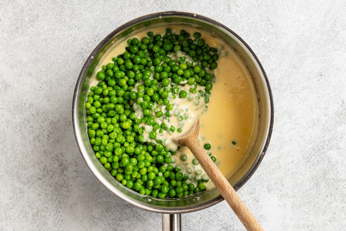 Taste of Home Cheesy Peas photo of adding the peas to the sauce.