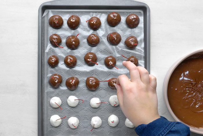dip cherries into chocolate; allow excess to drip off.