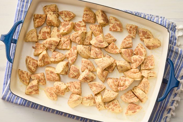Cinnamon Roll cut into pieces and placed on a blue dish