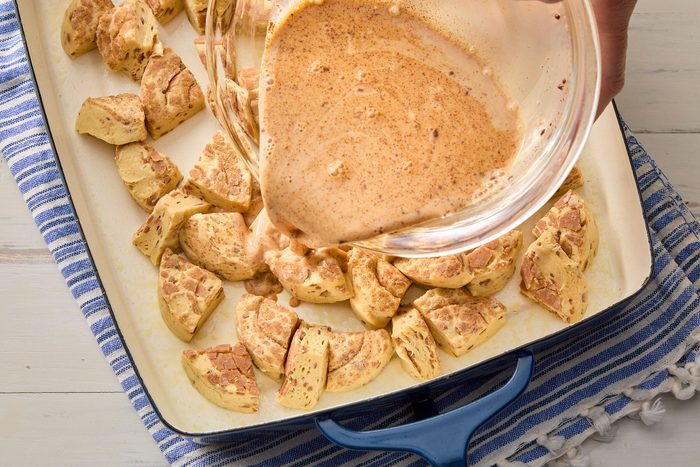 Sprinkling streusel mixture evenly over the cinnamon roll pieces