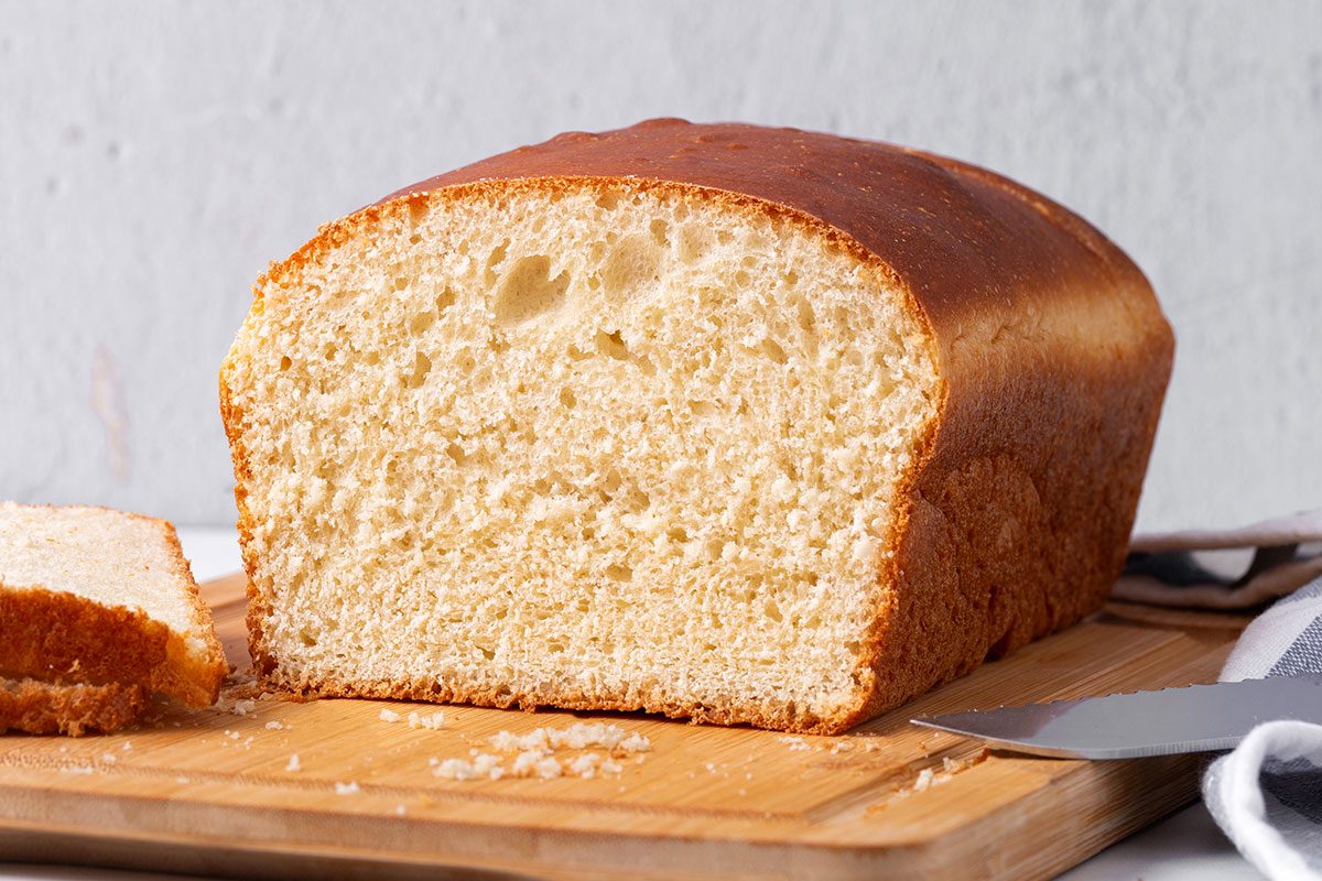 Sliced Country White Bread on a wooden cutting board for Taste of Home