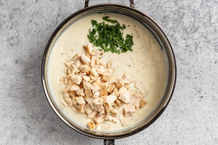 Taste of Home Creamed Chicken Over Biscuits photo of the chicken and parsley added to the cream sauce.