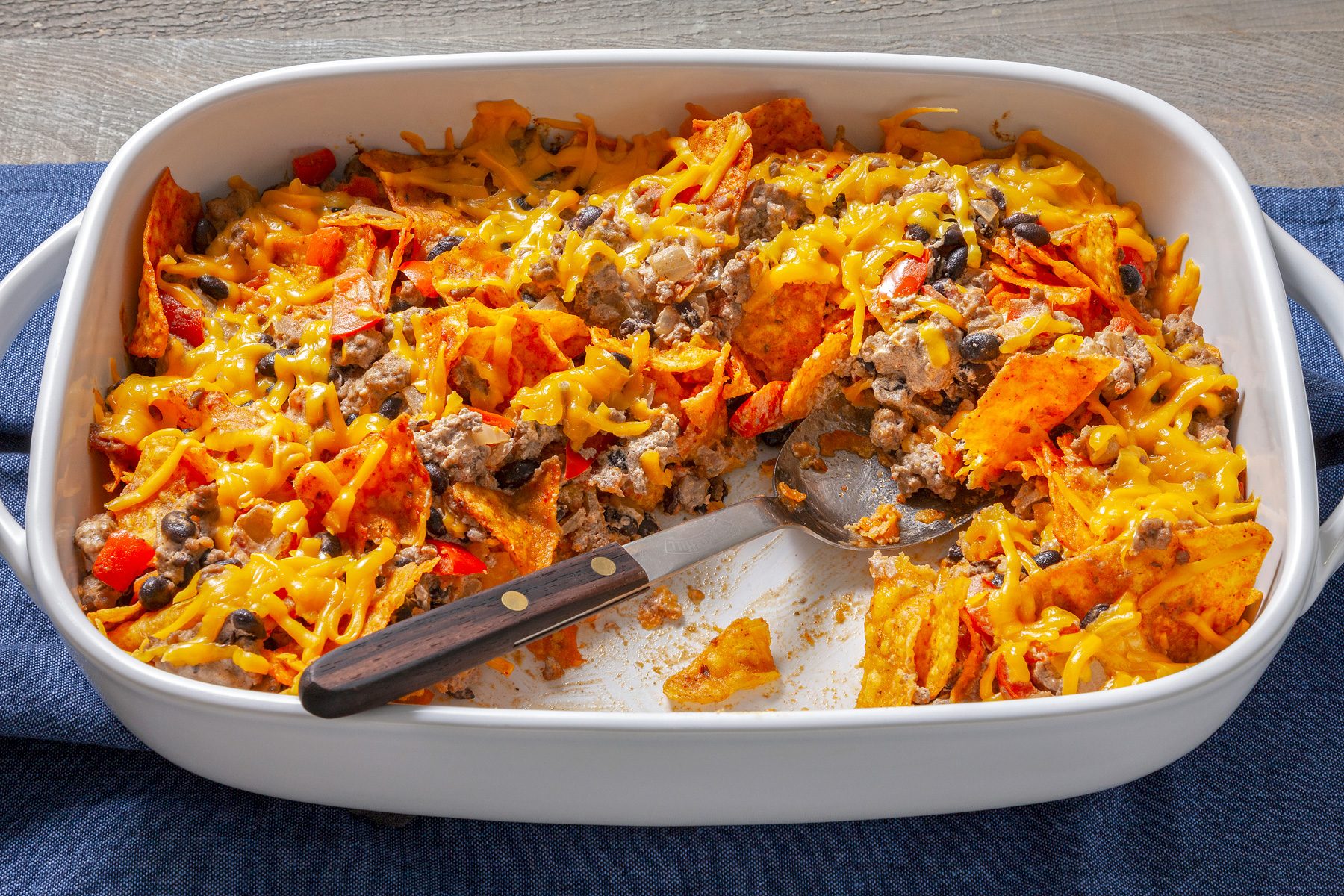 3/4 view of a Doritos casserole, showing layers of chips, cheese, and toppings.