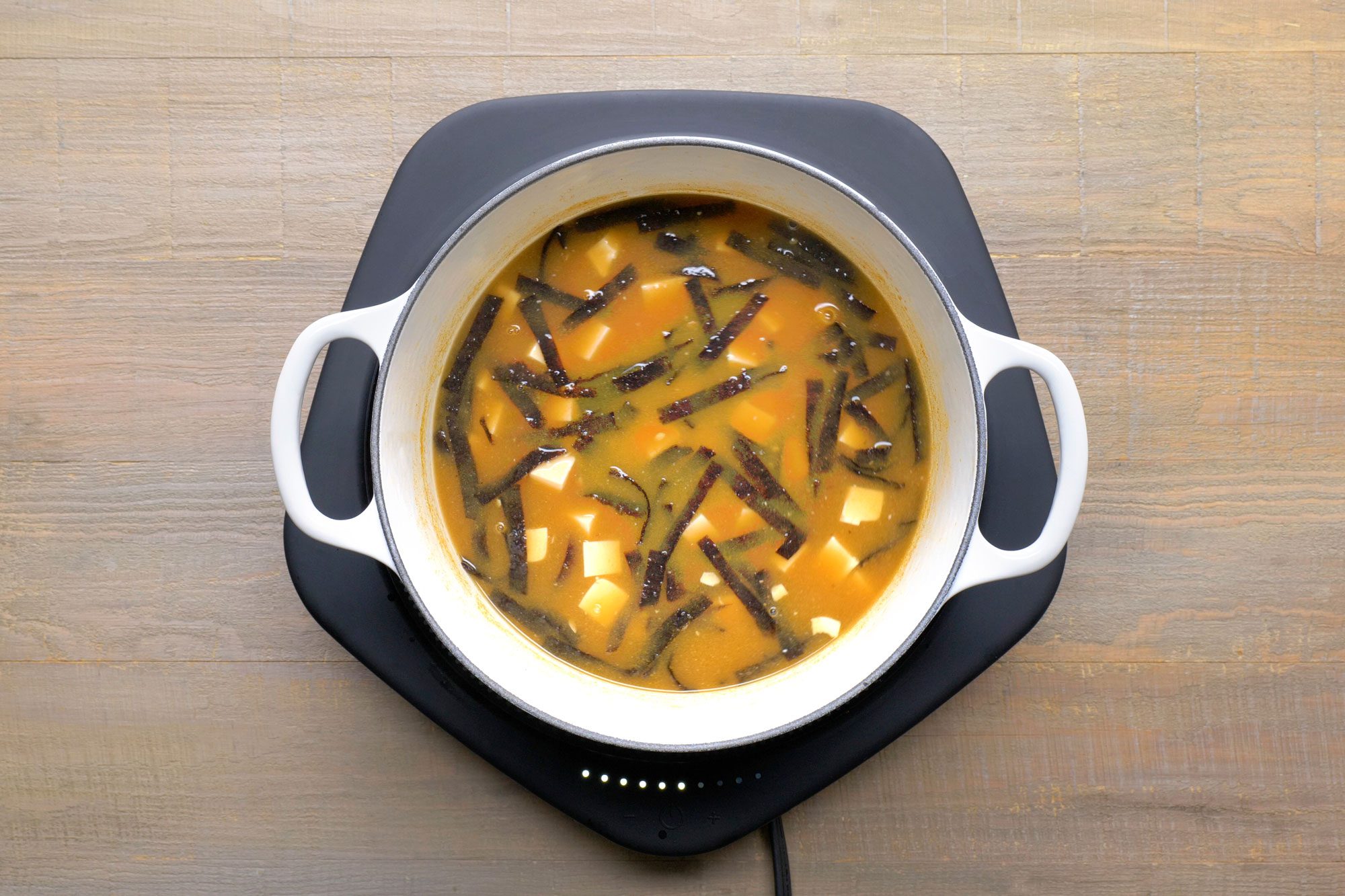 Overhead shot of add soy sauce; induction; wooden surface;